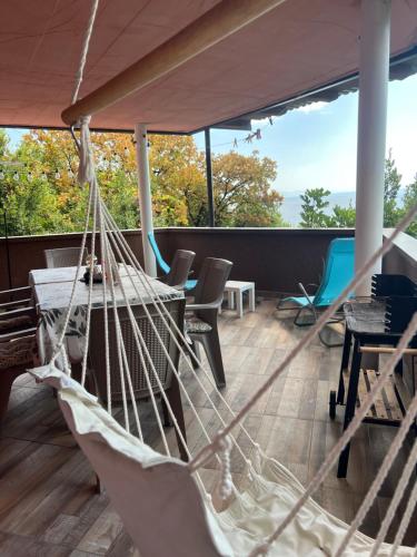 a hammock on the deck of a house at Salty Paws Medveja in Medveja