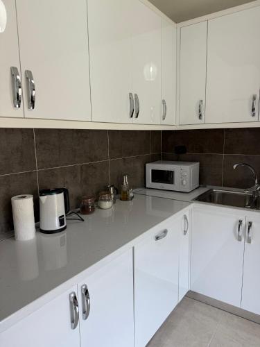 a kitchen with white cabinets and a microwave at Villa Gjoni in Kalmet
