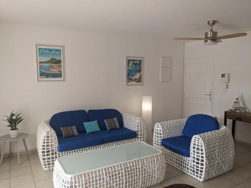 a living room with two chairs and a couch at Les terrasses de la Marina in Le Marin