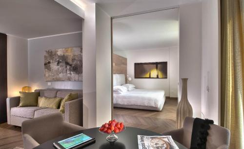 a hotel room with a bed and a living room at Esplanade Tergesteo - Luxury Retreat in Montegrotto Terme