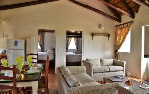 a living room with a table and chairs and a kitchen at Melkkamer Foremans Cottage in De Hoop Nature Reserve