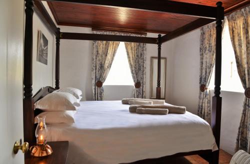 a bedroom with a large bed with white sheets and pillows at Melkkamer Foremans Cottage in De Hoop Nature Reserve