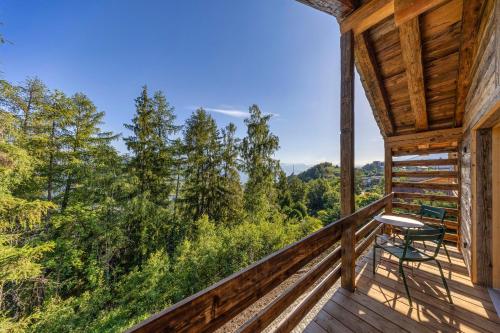 a log cabin balcony with a view of the mountains at MAD Retreat Hotel in Nendaz