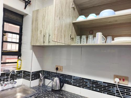 a kitchen with black and white tiles and a sink at Laimum 1br Milimani Zero700One4422Eight in Kisumu