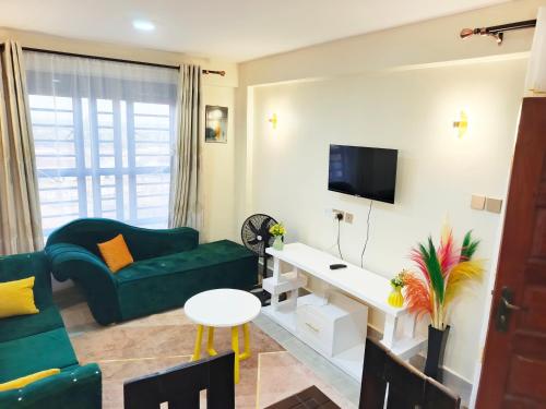 a living room with a green couch and a tv at Laimum 1br Milimani Zero700One4422Eight in Kisumu