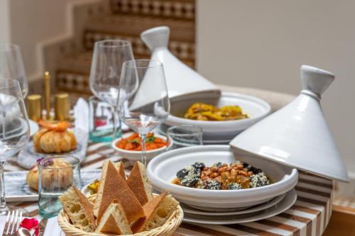 a table with plates of food and wine glasses at Riad AL-Ghazlan Hamam & Spa in Marrakech