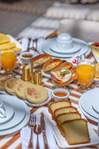 a table topped with plates of bread and orange juice at Riad AL-Ghazlan Hamam & Spa in Marrakech