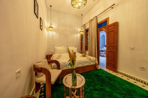 a bedroom with a bed and a green carpet at Riad AL-Ghazlan Hamam & Spa in Marrakech