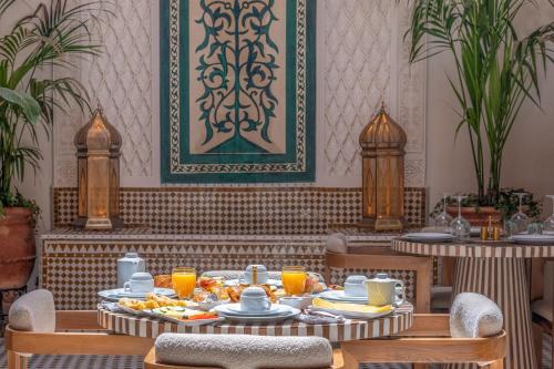 a dining room with a table with plates of food at Riad AL-Ghazlan Hamam & Spa in Marrakech