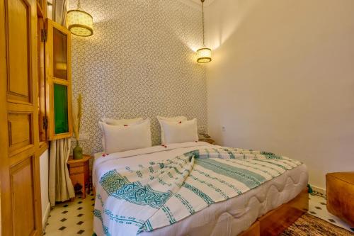 a bedroom with a large bed in a room at Riad AL-Ghazlan Hamam & Spa in Marrakech