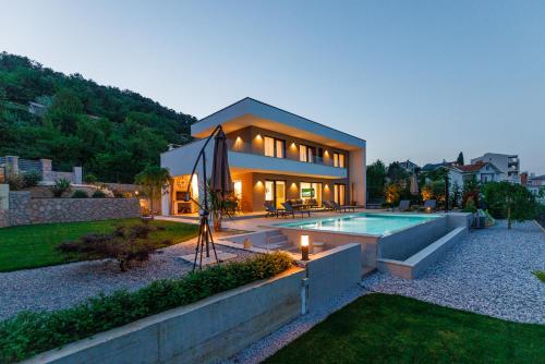 a house with a swimming pool in front of it at Villa Aria Prestige in Opatija