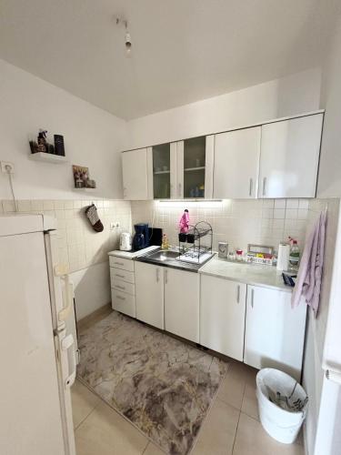 a kitchen with white cabinets and a sink at Apartments Tibra in Sarajevo