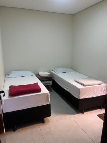 two beds sitting next to each other in a room at casa nova no guara proxima ao aeroporto in Brasilia