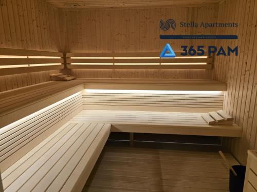 a sauna with a bench in the middle at Apartament Wiatr od Morza w Let's Sea - BASEN, JACUZZI, SAUNA, SIŁOWNIA, STREFA CHILL, PARKING W CENIE - 365PAM in Gąski