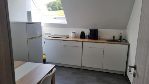 a kitchen with white cabinets and a wooden counter top at Mony land in Netphen