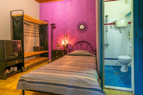 a bed in a room with a pink wall at Villa Yannis in Kato Korakiana