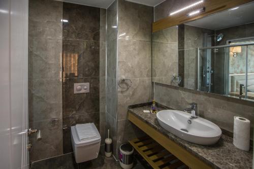 a bathroom with a sink and a toilet at Clementin Suits Sigacık in Siğacık