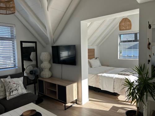 a bedroom with a bed and a flat screen tv at 35 On the Run in St Francis Bay