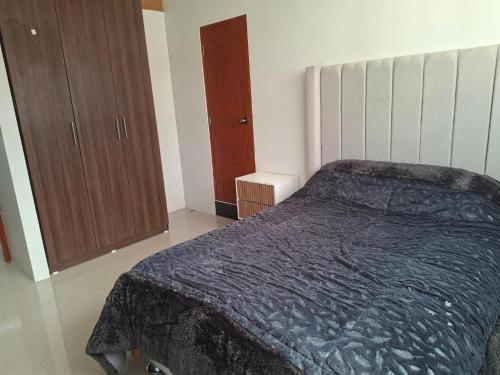a bedroom with a bed and a wooden cabinet at Casas Hogar Andina Huancayo in Huancayo