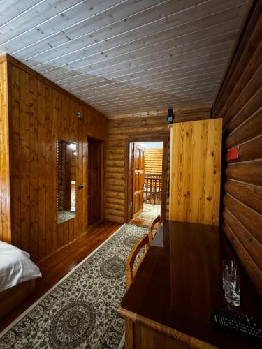 a room with a bed and a wooden wall at ProLes Burabay Eco Hotel in Borovoye