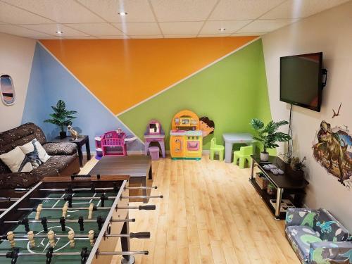a living room with a playroom with a large wall at Family Chalet - Le Bosquet in Scott
