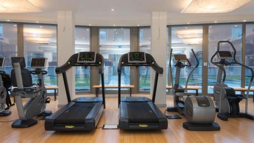 a gym with several treadmills and elliptical machines at Hotel Cruise in Lucino