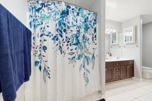 a bathroom with a shower with a blue and white shower curtain at SkyNest in Running Springs