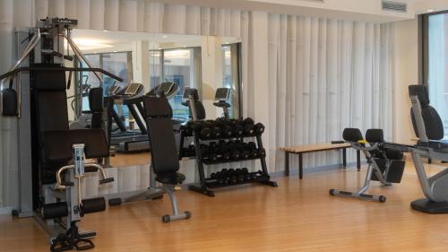a gym with several treadmills and exercise bikes at Hotel Cruise in Lucino