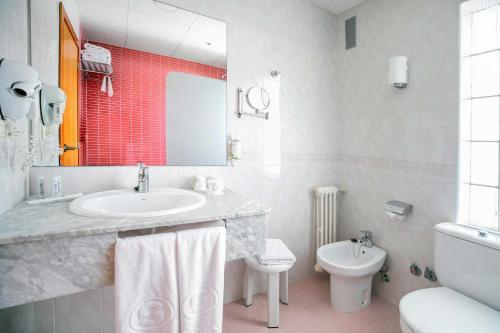 a white bathroom with a sink and a toilet at Hotel Servigroup La Zenia 4 Sup in Playas de Orihuela