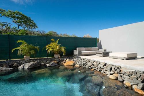a swimming pool with a rock retaining wall and a backyard at Villa des Rochers in Saint-François