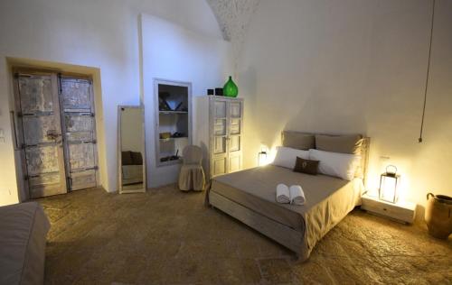 a bedroom with a bed with two white shoes on it at Palazzo Castriota in Alezio