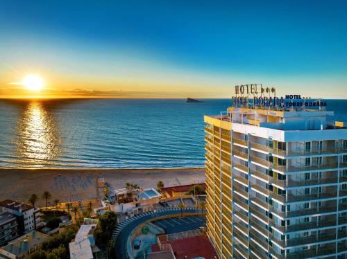 a view of a hotel and the beach at sunset at Hotel Servigroup Torre Dorada in Benidorm