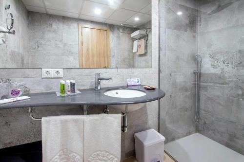 a bathroom with a sink and a shower at Hotel Servigroup Koral Beach 4 Sup in Oropesa del Mar