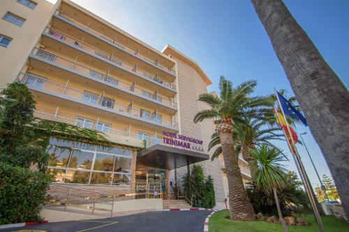 a hotel with palm trees in front of it at Hotel Servigroup Trinimar in Benicàssim