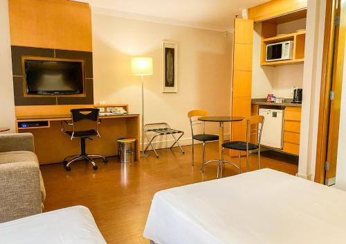 a room with a bed and a table and chairs at Transamerica Executive Jardins in Sao Paulo