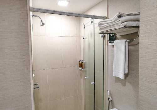 a bathroom with a shower and a toilet and towels at Transamerica Executive Jardins in Sao Paulo