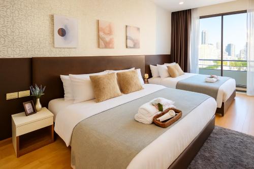 a hotel room with two beds with towels on them at Great Balcony with 2 Beds Executive Unit in Bangkok
