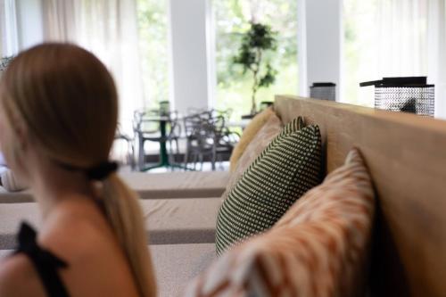 a woman sitting on a couch in a living room at Medlefors Hotell & Konferens in Skellefteå