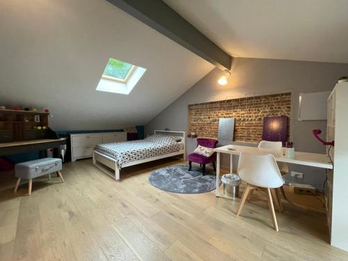 a bedroom with a bed and a table and chairs at Typical Toulouse house completely renovated in Launaguet