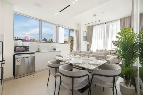 a kitchen and dining room with a table and chairs at Private Pool! Exceptional 2 Bedroom! Brand New Building with Pool and Gym! in Dubai