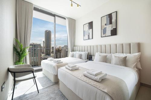 two beds in a bedroom with a large window at Private Pool! Exceptional 2 Bedroom! Brand New Building with Pool and Gym! in Dubai