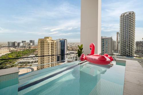 a swimming pool with a red swan float on top of a building at Private Pool! Exceptional 2 Bedroom! Brand New Building with Pool and Gym! in Dubai