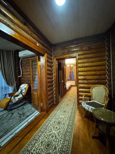 a living room with wooden walls and a table and chairs at ProLes Burabay Eco Hotel in Borovoye