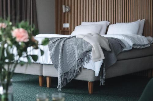 a bedroom with a bed with a blanket on it at Medlefors Hotell & Konferens in Skellefteå