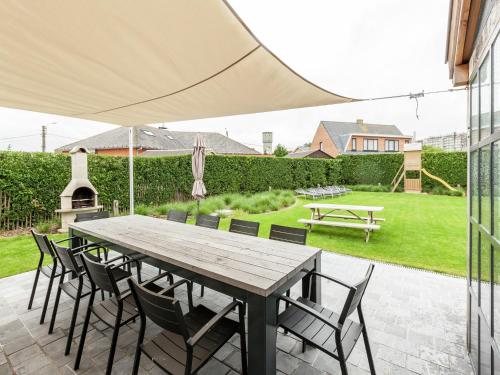 Una mesa y sillas de madera en un patio. en Beach Home with Bubble Bath, en Middelkerke