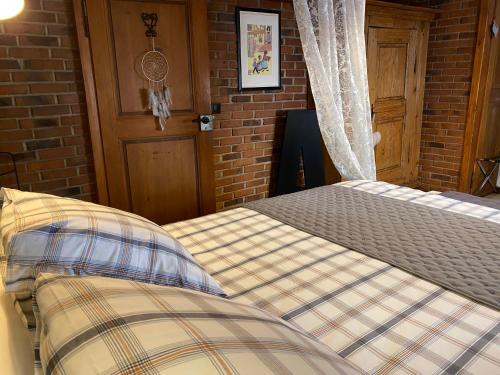a bedroom with two beds and a brick wall at Gîte de caractère au calme , proche quartier historique, Au Merlenchanteur in Schiltigheim