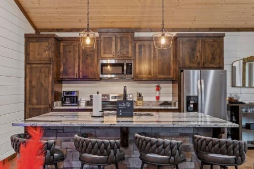 a kitchen with wooden cabinets and a large counter with chairs at BEARLY BEHAVIN NEW SEXY Cabin Adult Getaway in Broken Bow