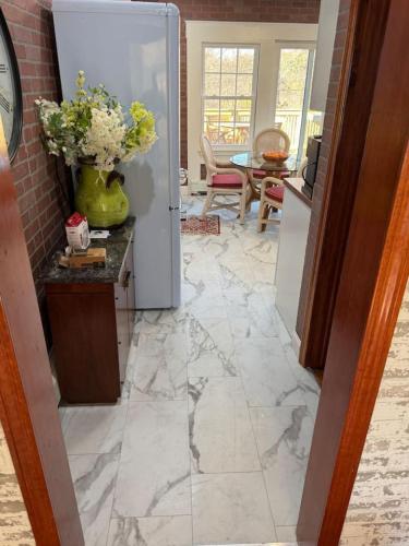 a kitchen with a marble floor and a refrigerator at The Cozy Creamery in Plainville