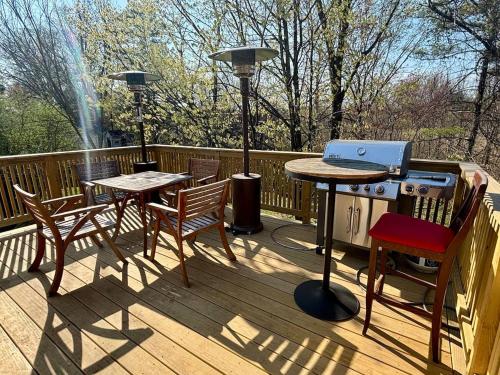 a grill on a deck with two tables and chairs at The Cozy Creamery in Plainville