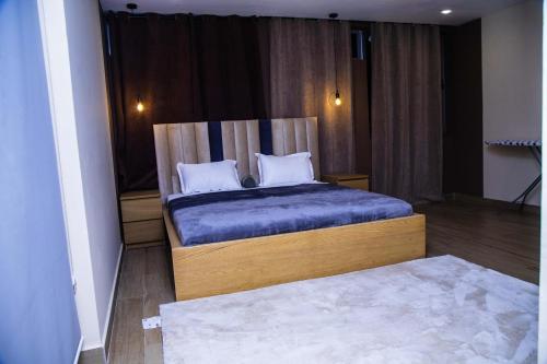 a bedroom with a bed with blue sheets and pillows at PLSA airport city 2bedroom in Accra
